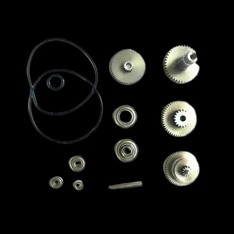 A collection of various gears, bearings, and seals, likely made of metal, displayed against a black background.