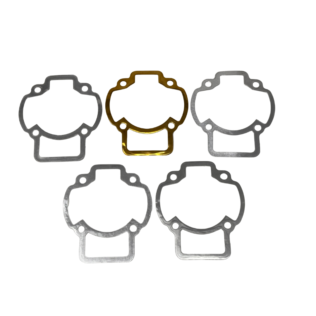 Set of five gaskets with one gold-colored gasket on a white background