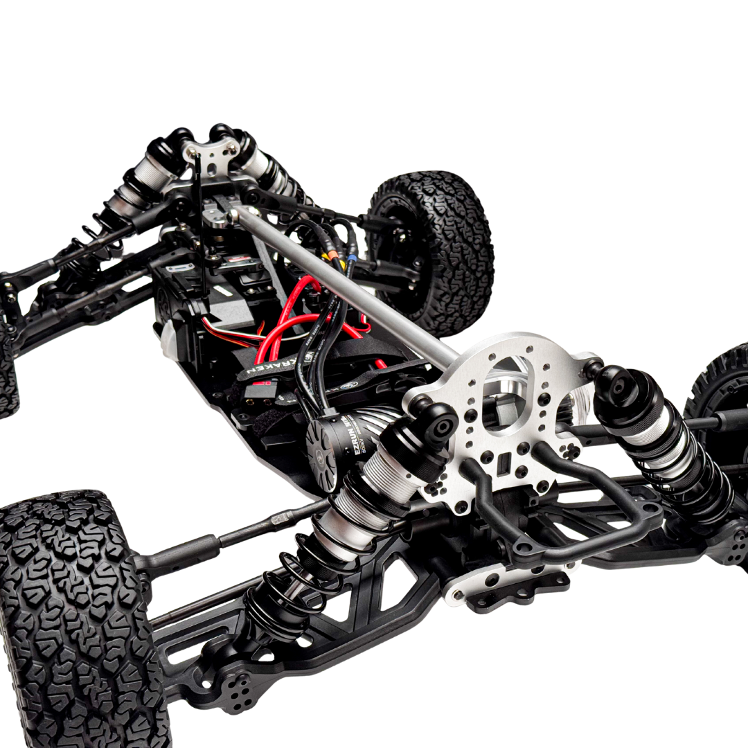 Close-up of a detailed model car chassis with suspension and wheels on a white background