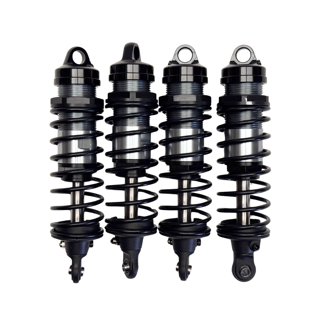 Four black shock absorbers on a white background