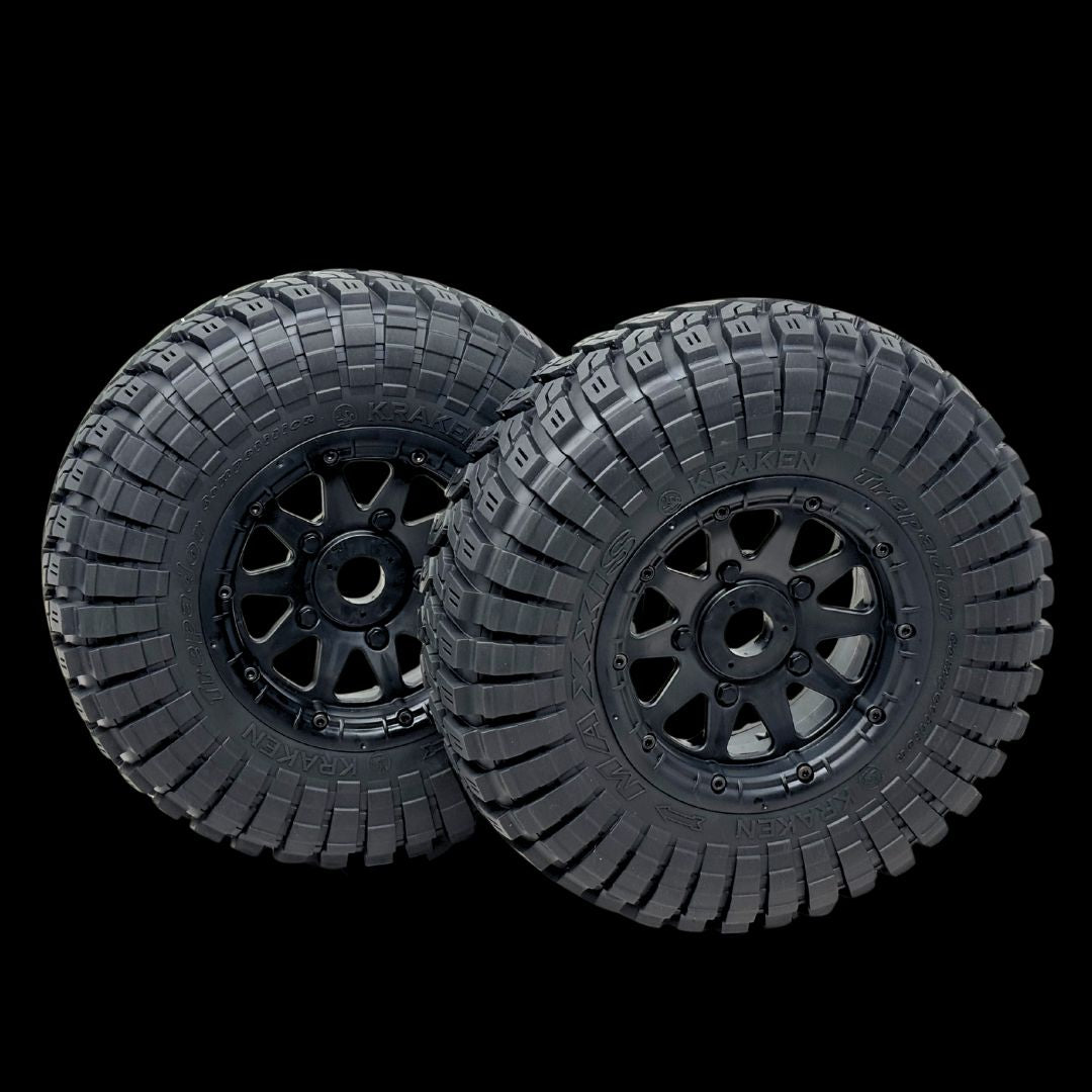 Two black off-road tires with tread patterns on a transparent background