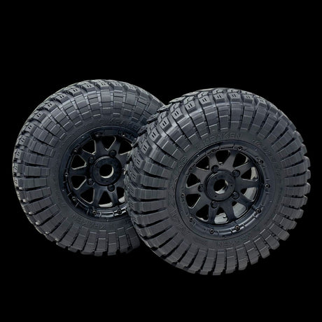 Two black off-road tires with tread patterns on a transparent background