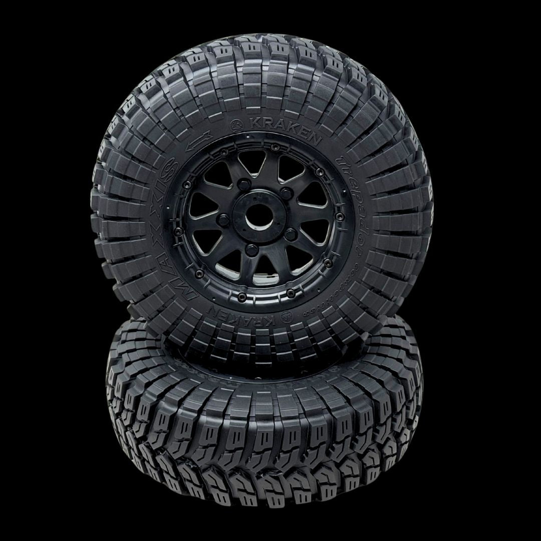 Two black off-road tires with tread patterns on a transparent background
