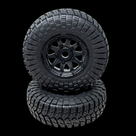 Two black off-road tires with tread patterns on a transparent background