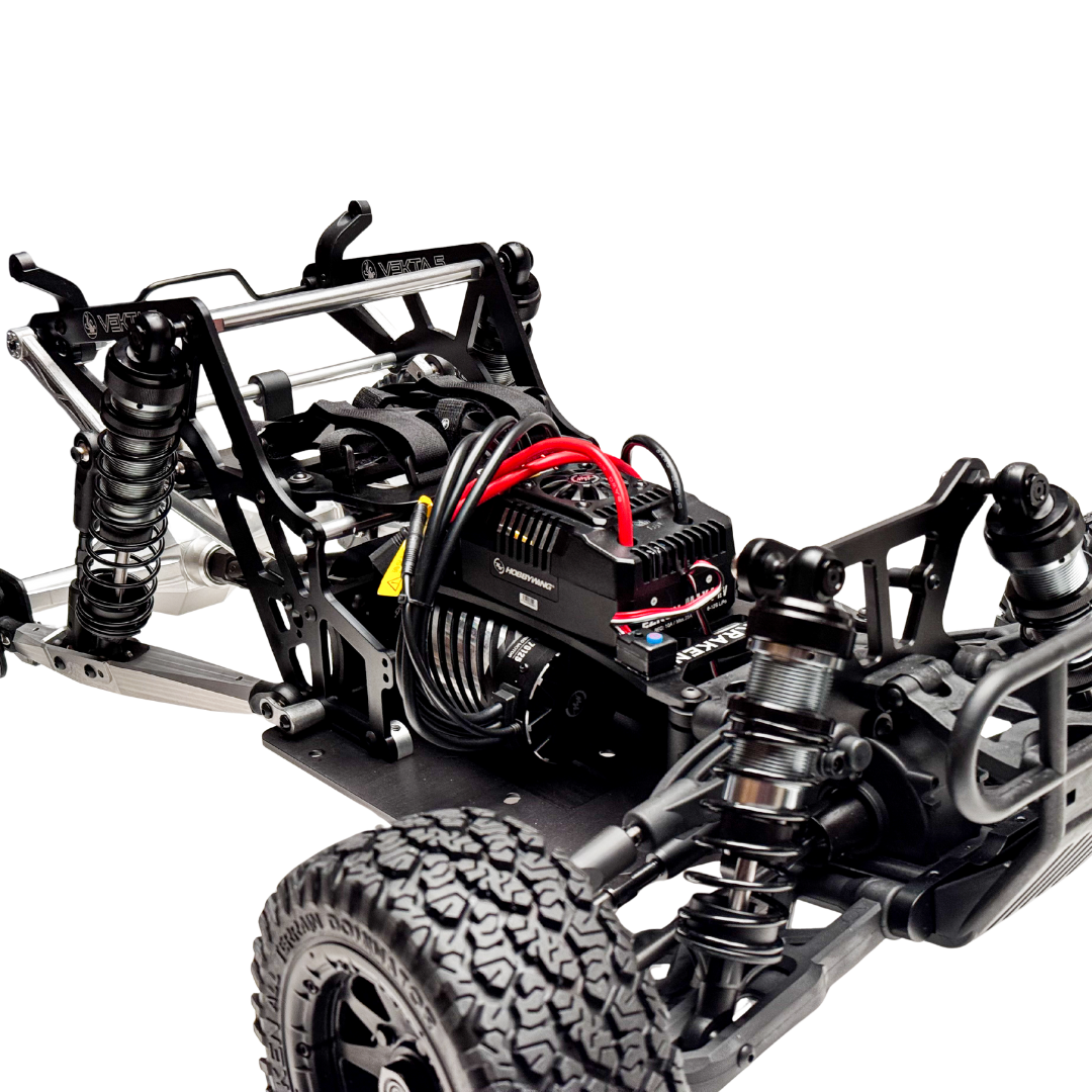 Close-up of a black and silver RC car chassis with visible components on a white background
