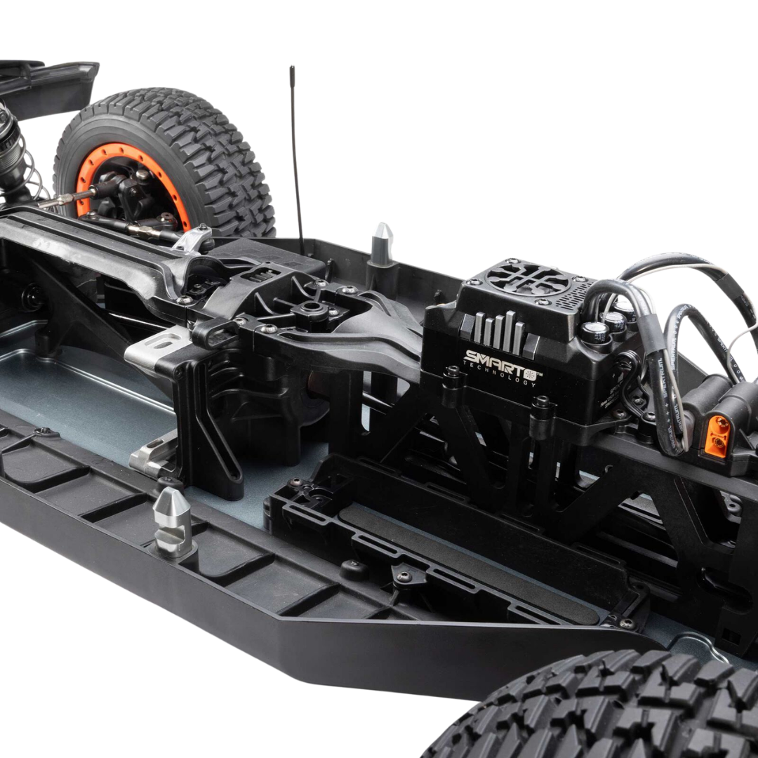 Close-up of a remote control car chassis with visible branding on a white background