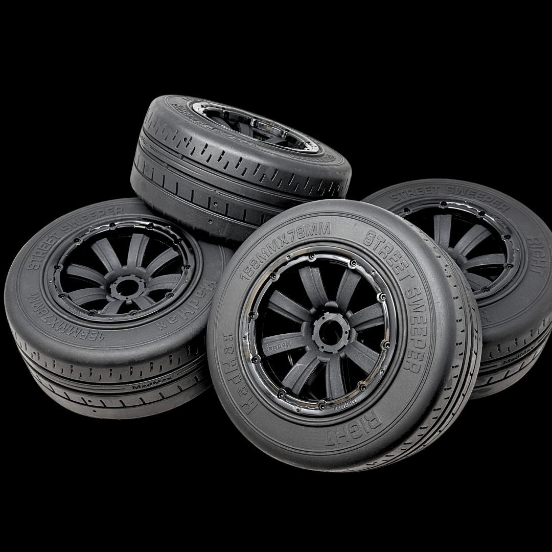 Four model tires with visible treads on a black background