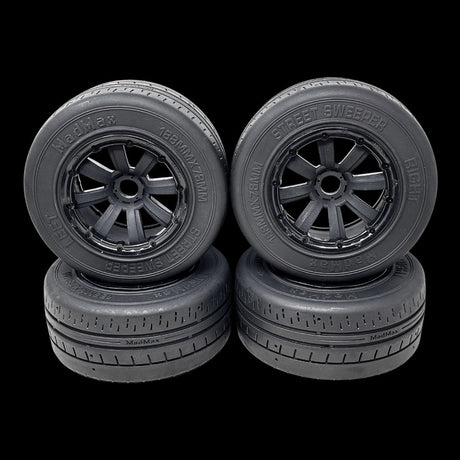 Four black model car wheels with detailed treads on a transparent background