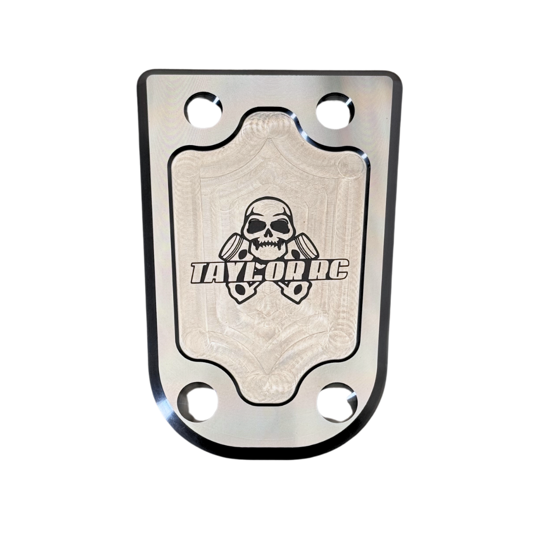 Metallic plate with skull design and 'Taylor RC' branding on a white background