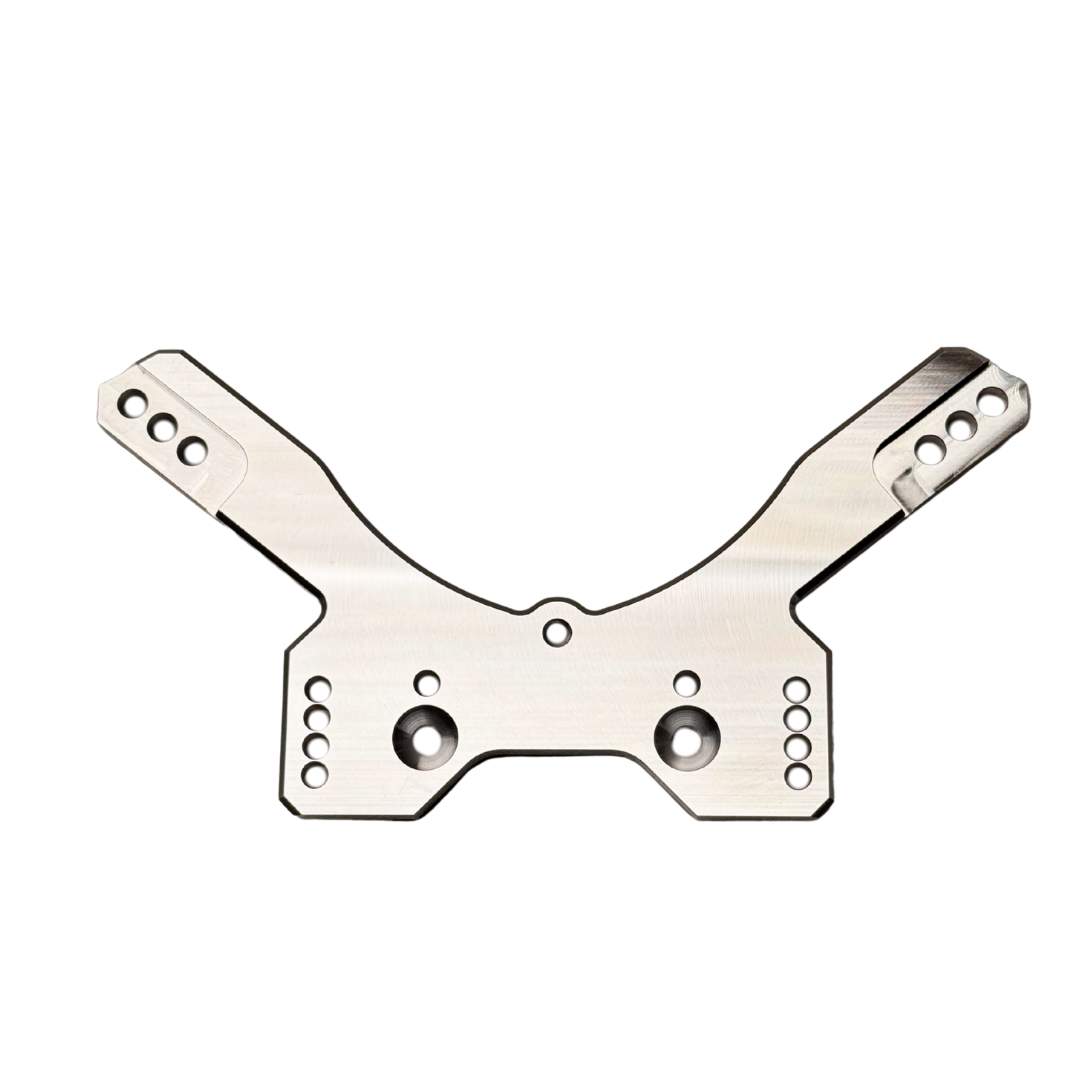 Taylor RC OUTLAW drop rear shock tower in raw silver, flat top-down view showing the mounting holes and central cutout from a slightly different angle