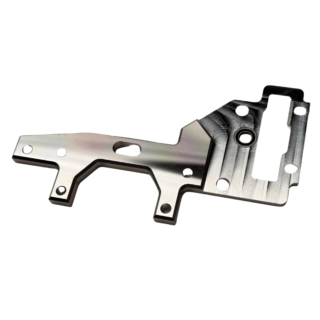 Taylor RC OUTLAW V4 upper transmission plate in raw silver, angled view showing the mounting holes, bearing bore, and slotted cutout