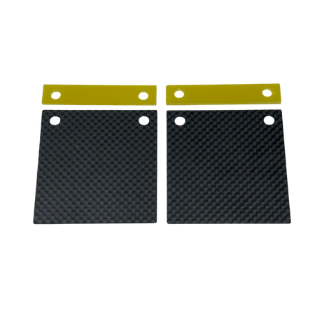 Two black carbon fiber plates with gold straps on a white background