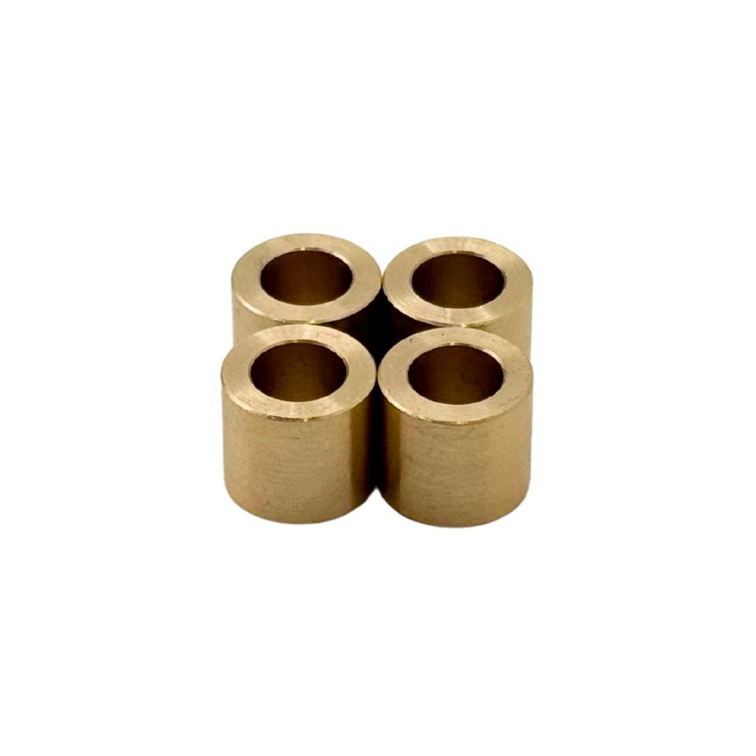 Four cylindrical brass bearings arranged in a cross formation on a white background.