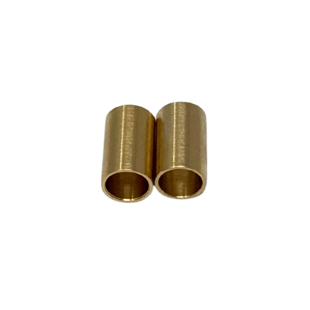Two brass cylindrical bushings on a white background