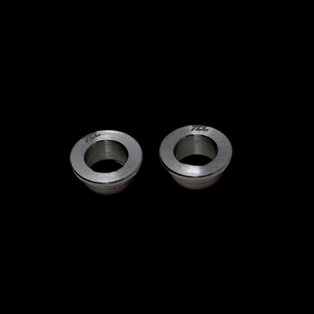 Two metal bushings on a black background