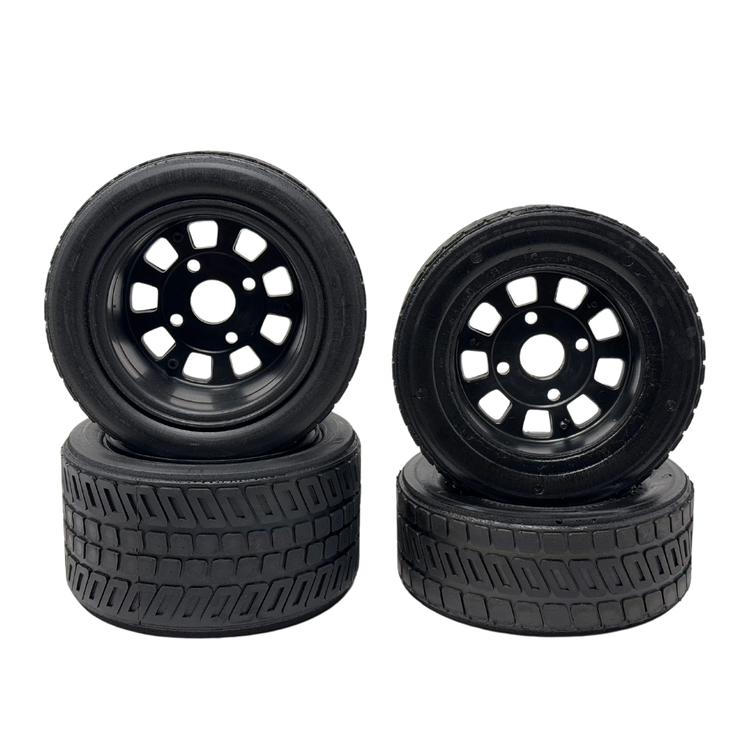Four black wheels with tread patterns on a white background