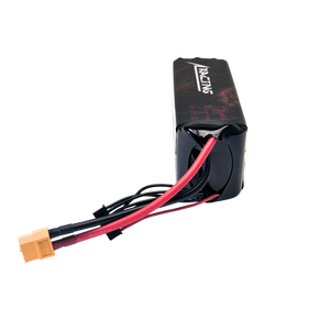 Black battery pack with red and black cables on a white background