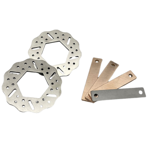 Two metal brake rotors and three metal feeler blades on a white background