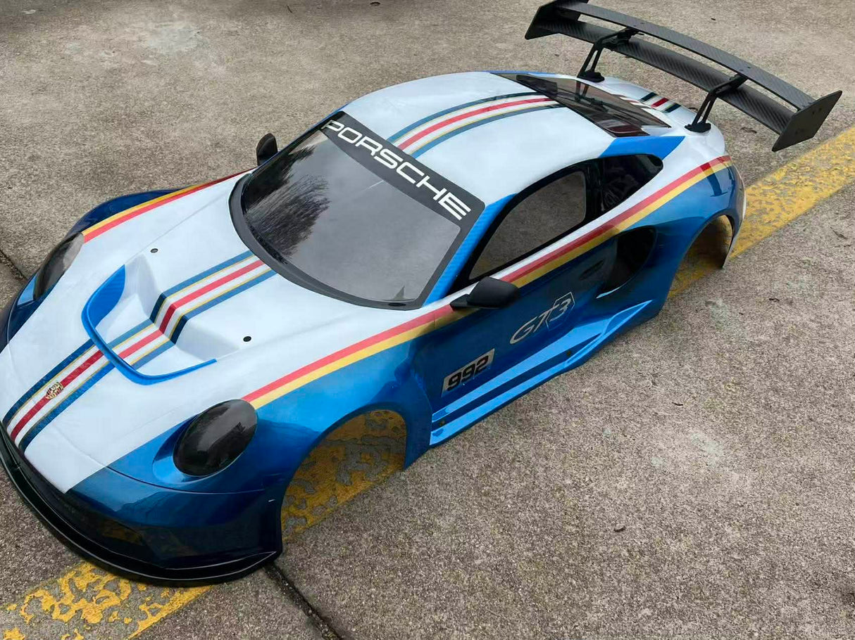 Porsche race car with distinctive stripes on a concrete surface