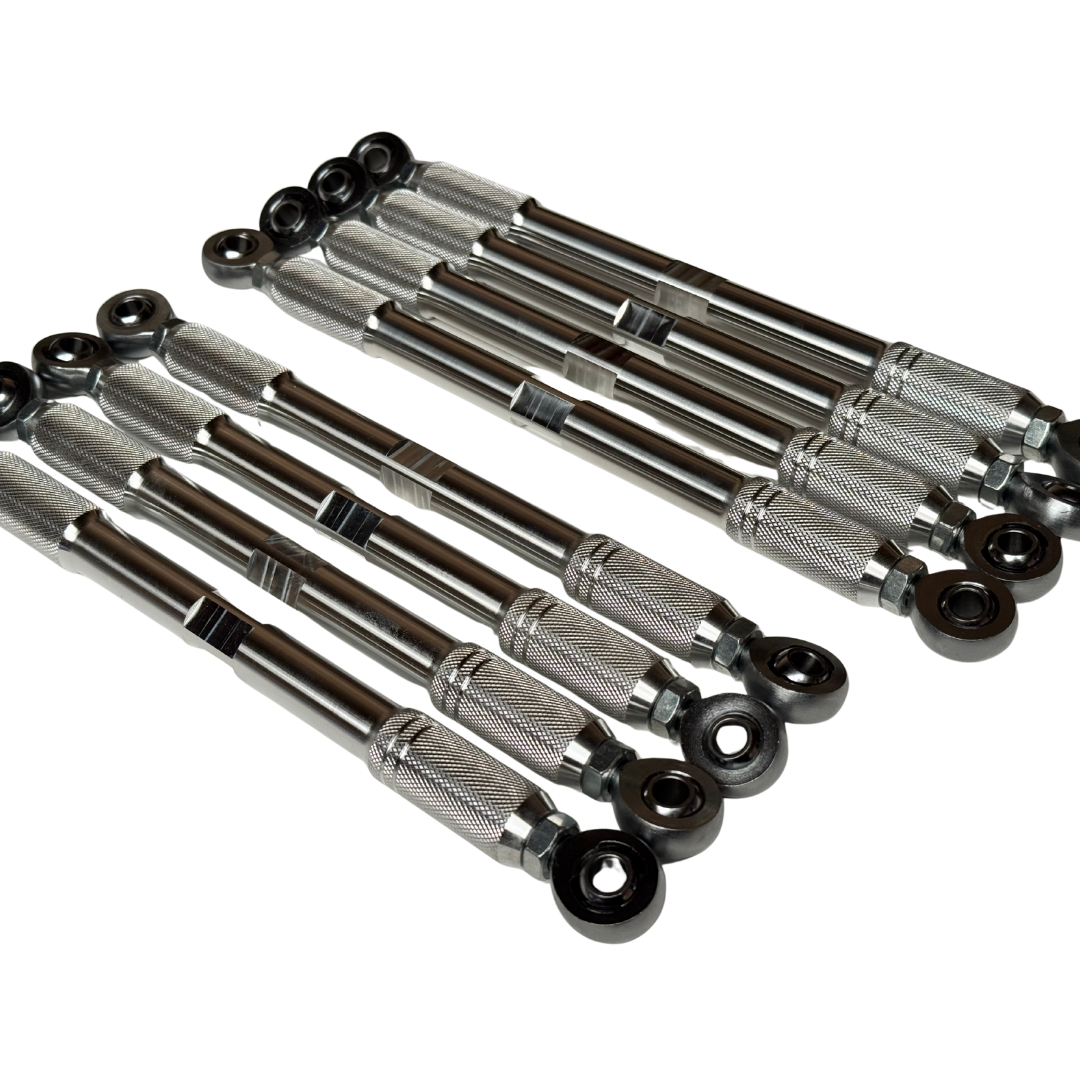 A set of metallic steering knuckle bushings with black rubber spherical ends, arranged diagonally on a plain white background.