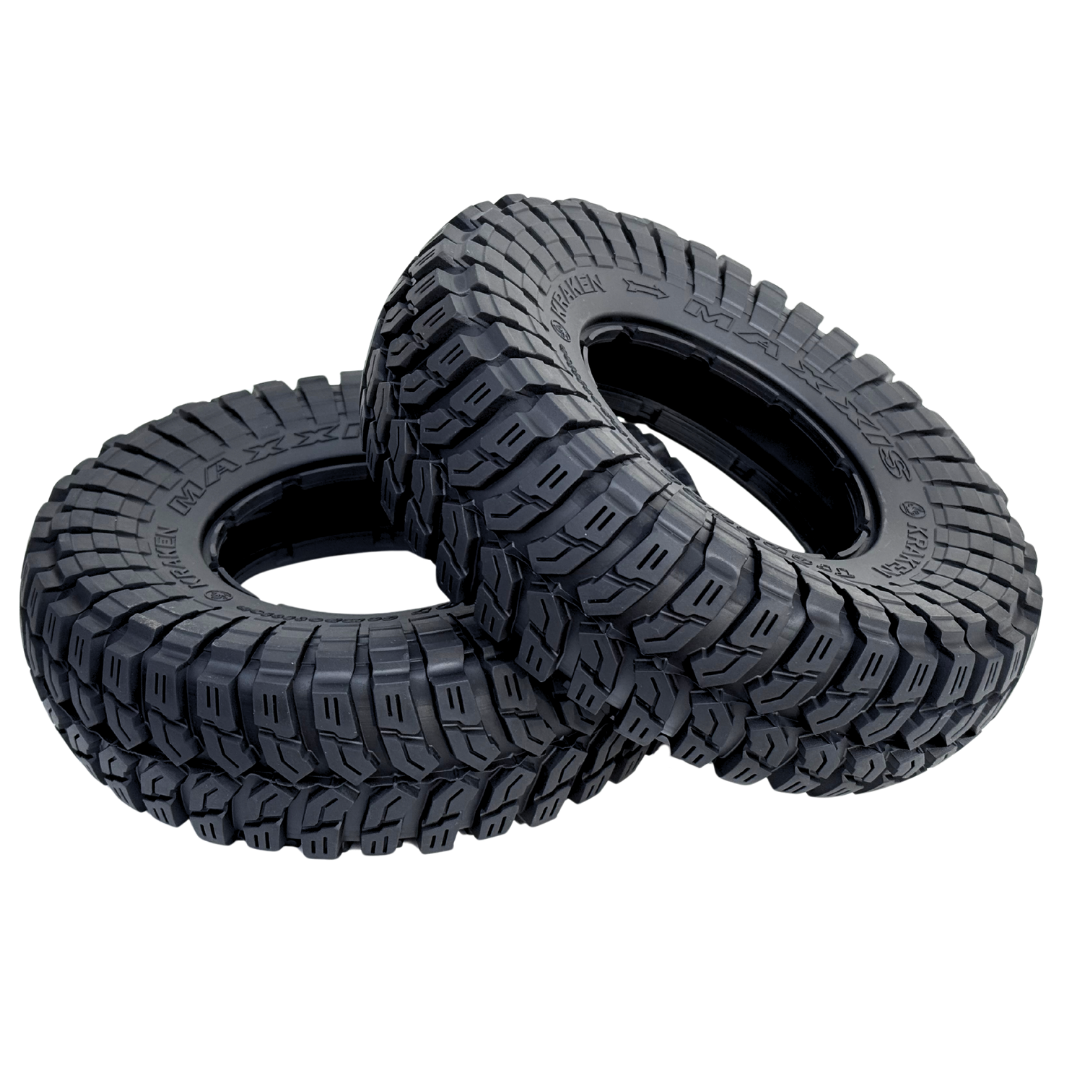 Two black off-road tires with tread pattern on a white background