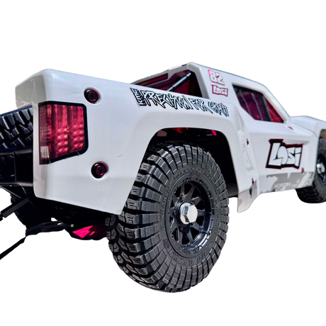 White off-road vehicle with large black tires on a white background