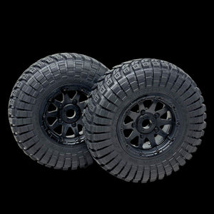 Two black off-road tires with tread patterns on a transparent background