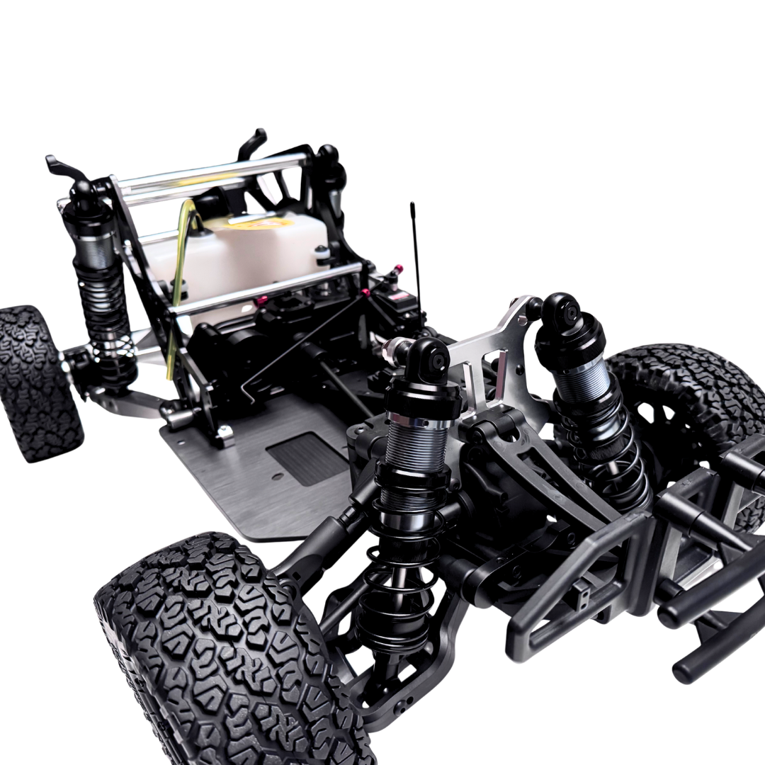 Close-up of a detailed model car chassis with suspension and tires on a white background