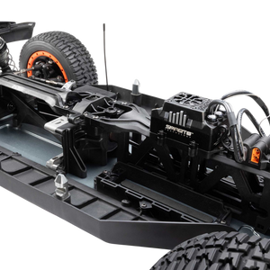 Close-up of a remote control car chassis with visible branding on a white background