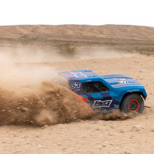 Blue off-road racing truck with number 53 driving on a dirt track