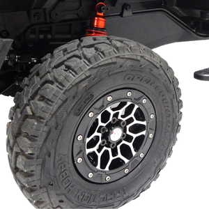 Off-road tire with a black and silver rim on a white background