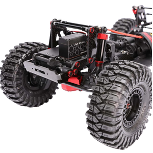 Close-up of a remote control monster truck chassis with large tires on a white background