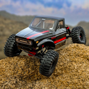 Model of a black off-road vehicle with red accents on a rocky terrain