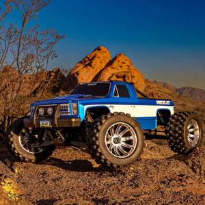 Blue and white remote control truck on a rocky desert landscape