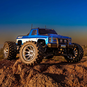 Blue off-road model truck on a rocky surface with a clear sky