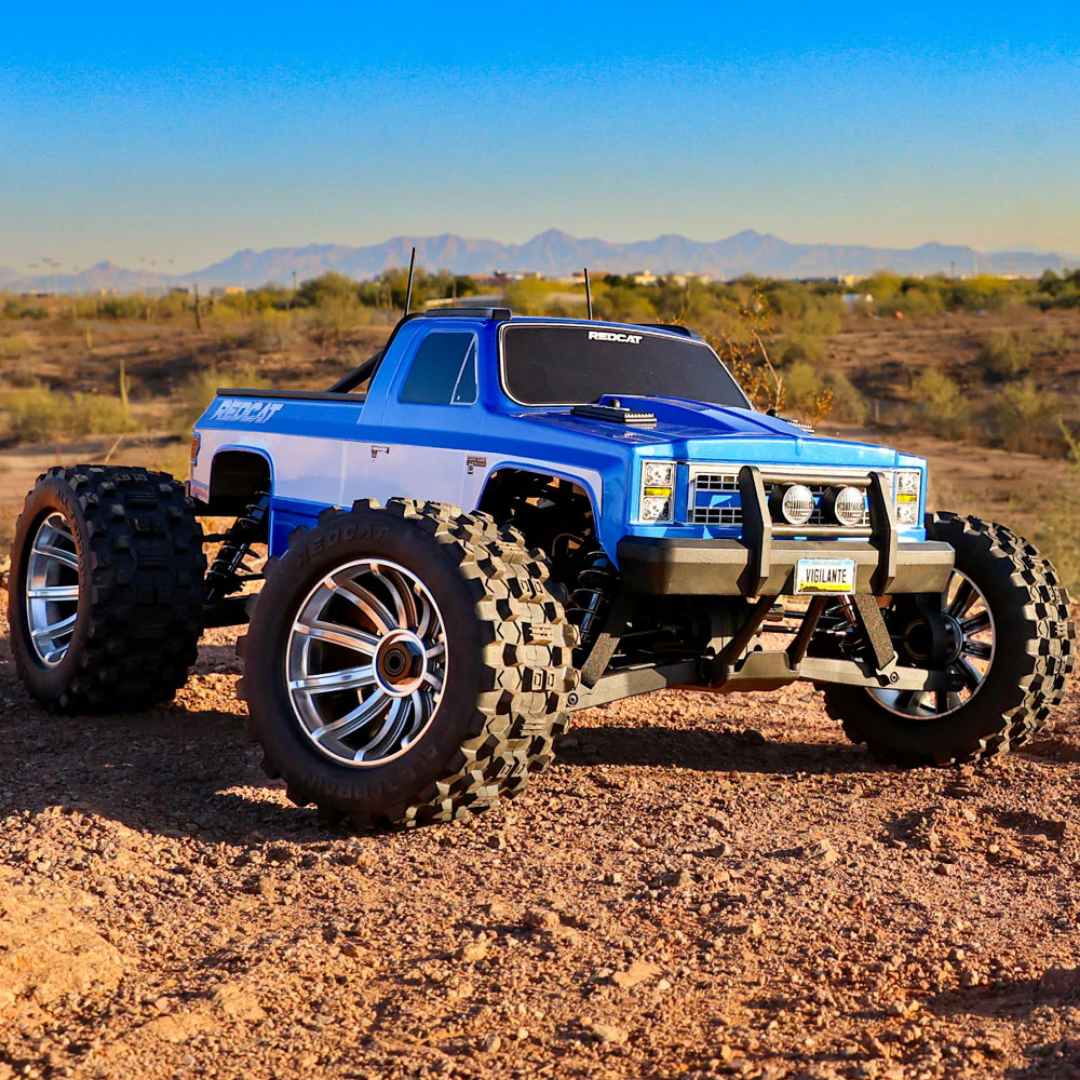 Blue off-road truck with large tires in a desert landscape