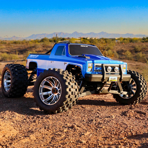 Blue off-road truck with large tires in a desert landscape