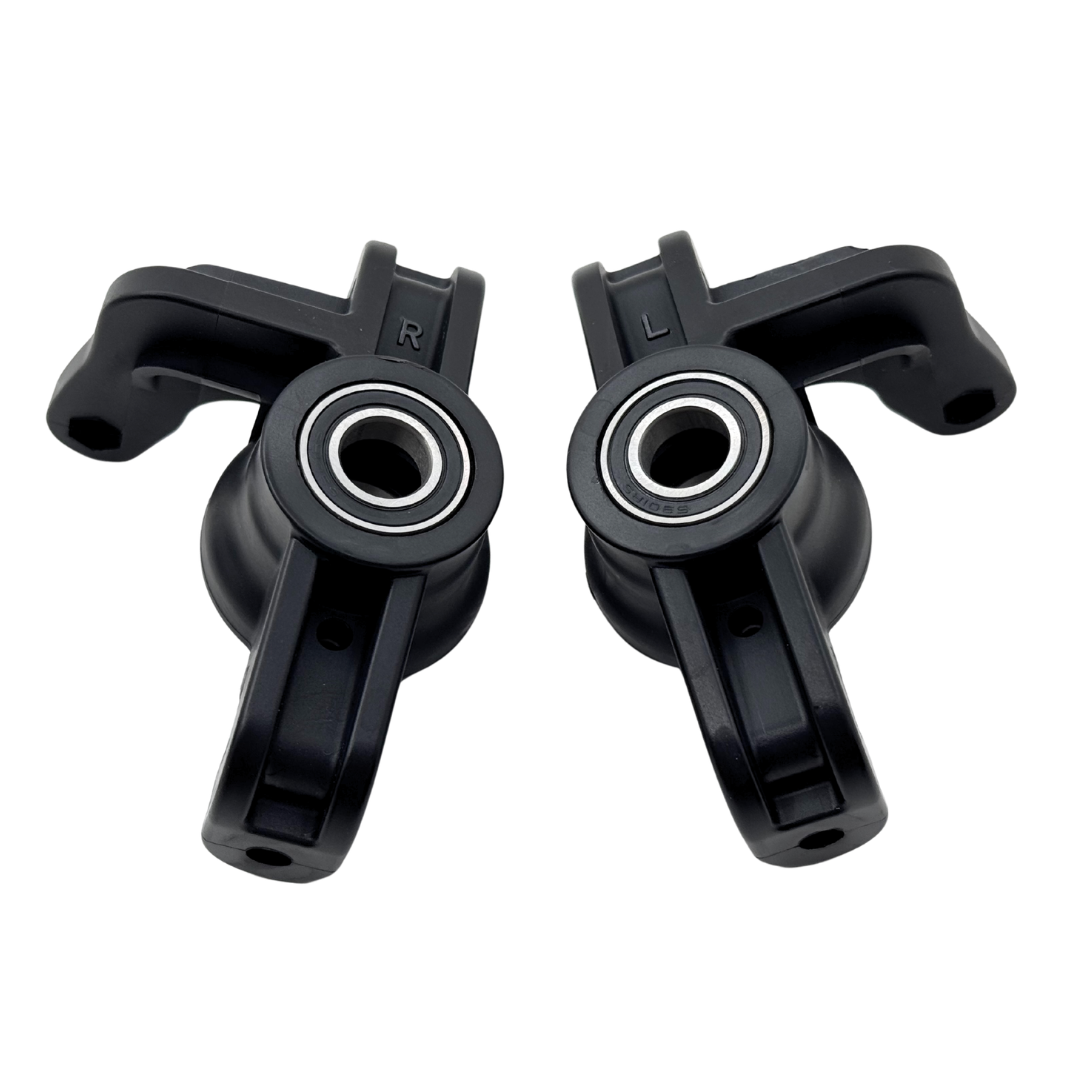 Two black plastic components with bearings on a white background