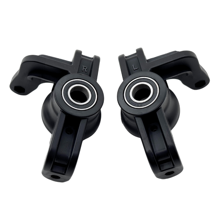 Two black plastic components with bearings on a white background