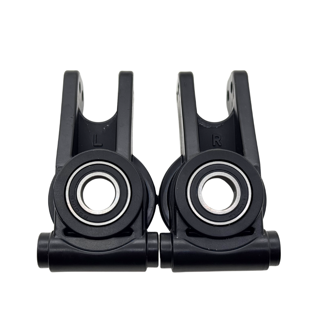 Two black plastic components with bearings on a white background