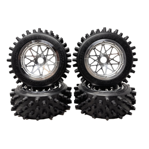 Four black off-road wheels with spiky tire treads on a white background