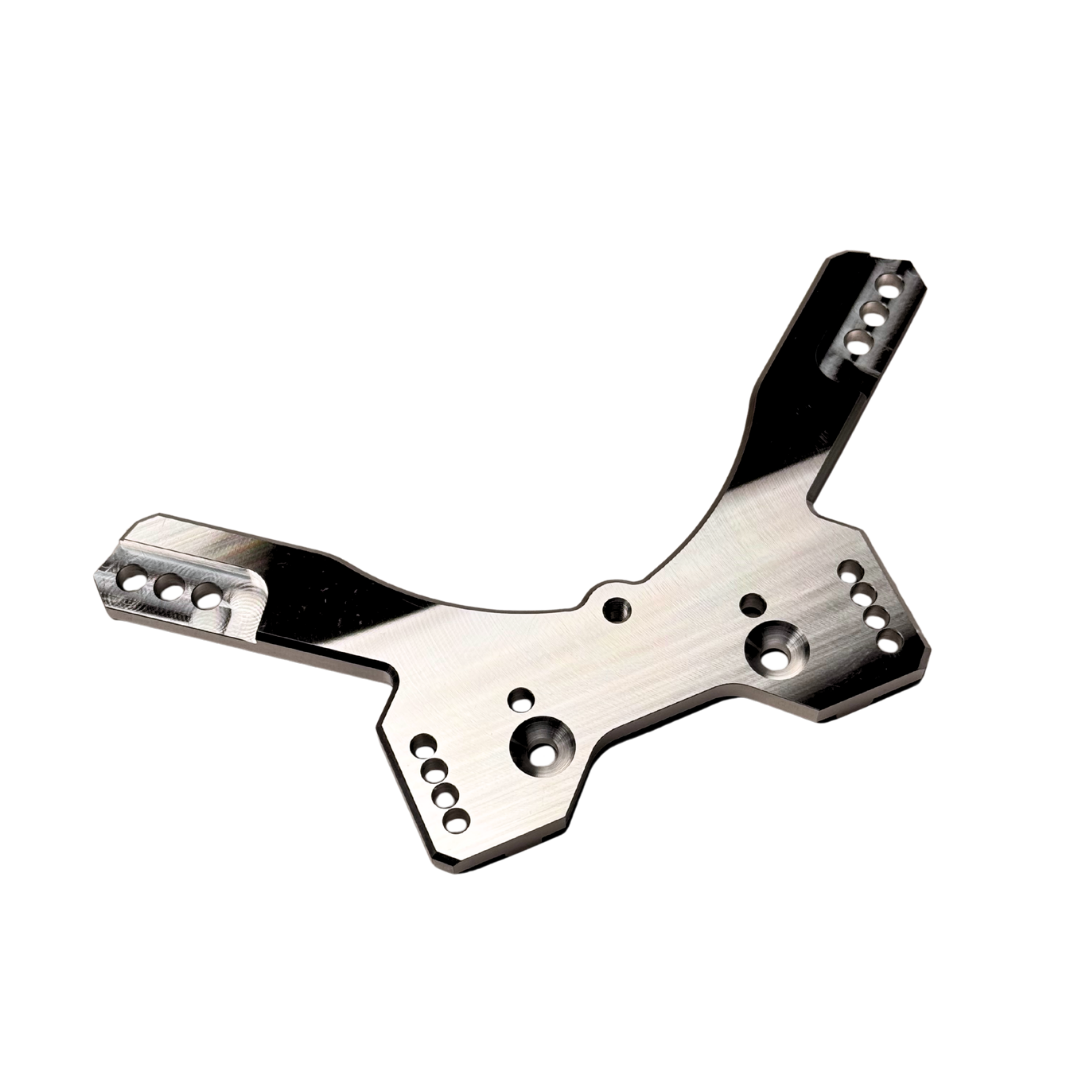 Taylor RC OUTLAW drop rear shock tower in raw silver, angled view from the opposite side showing the shock mounting holes and arm slots