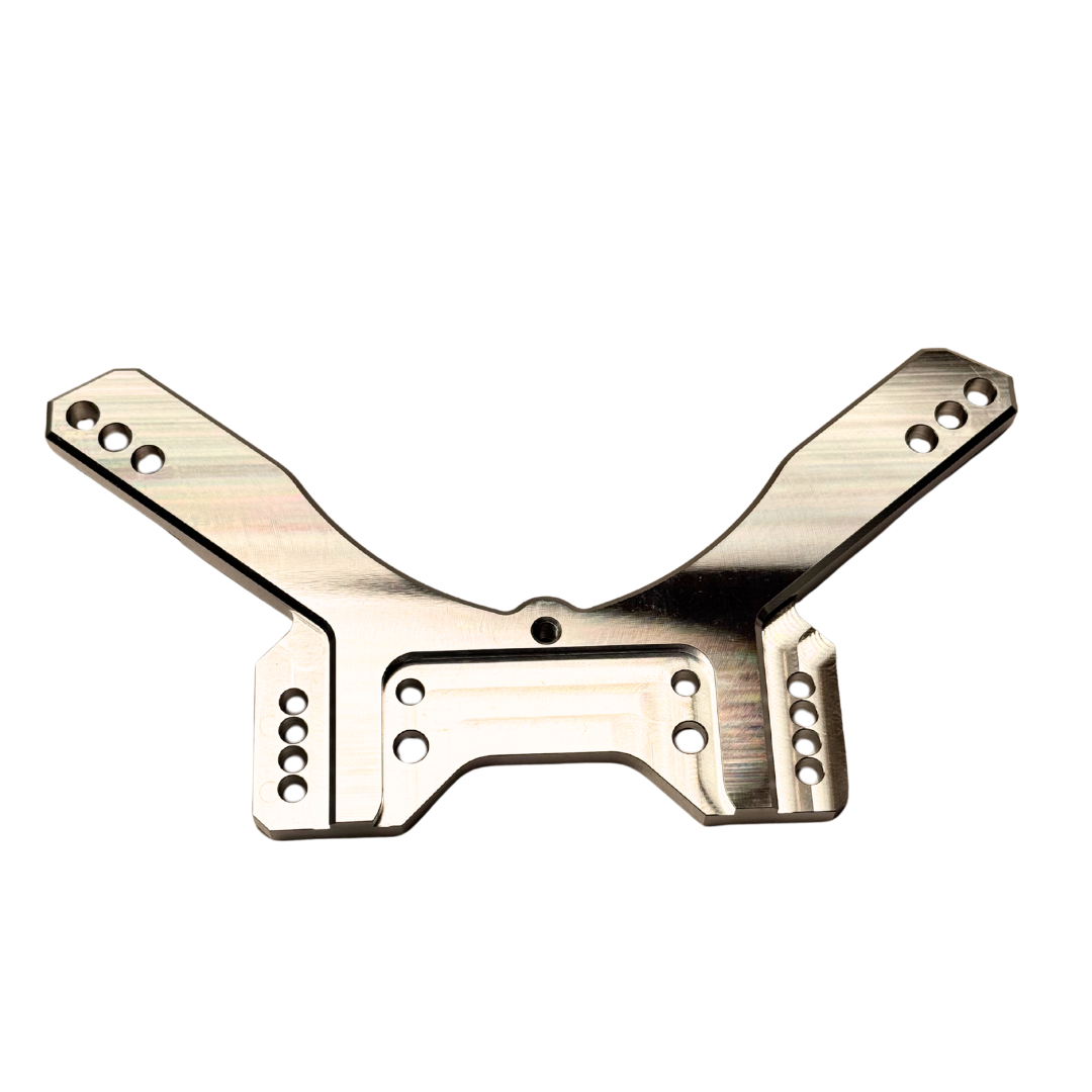 Taylor RC OUTLAW drop rear shock tower in raw silver, flat top-down view showing the full symmetrical arm layout and central cutout