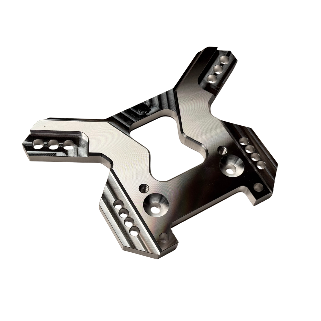 Taylor RC OUTLAW V4 front shock tower in raw silver, angled view from the opposite side showing the shock mounting holes and arm slots