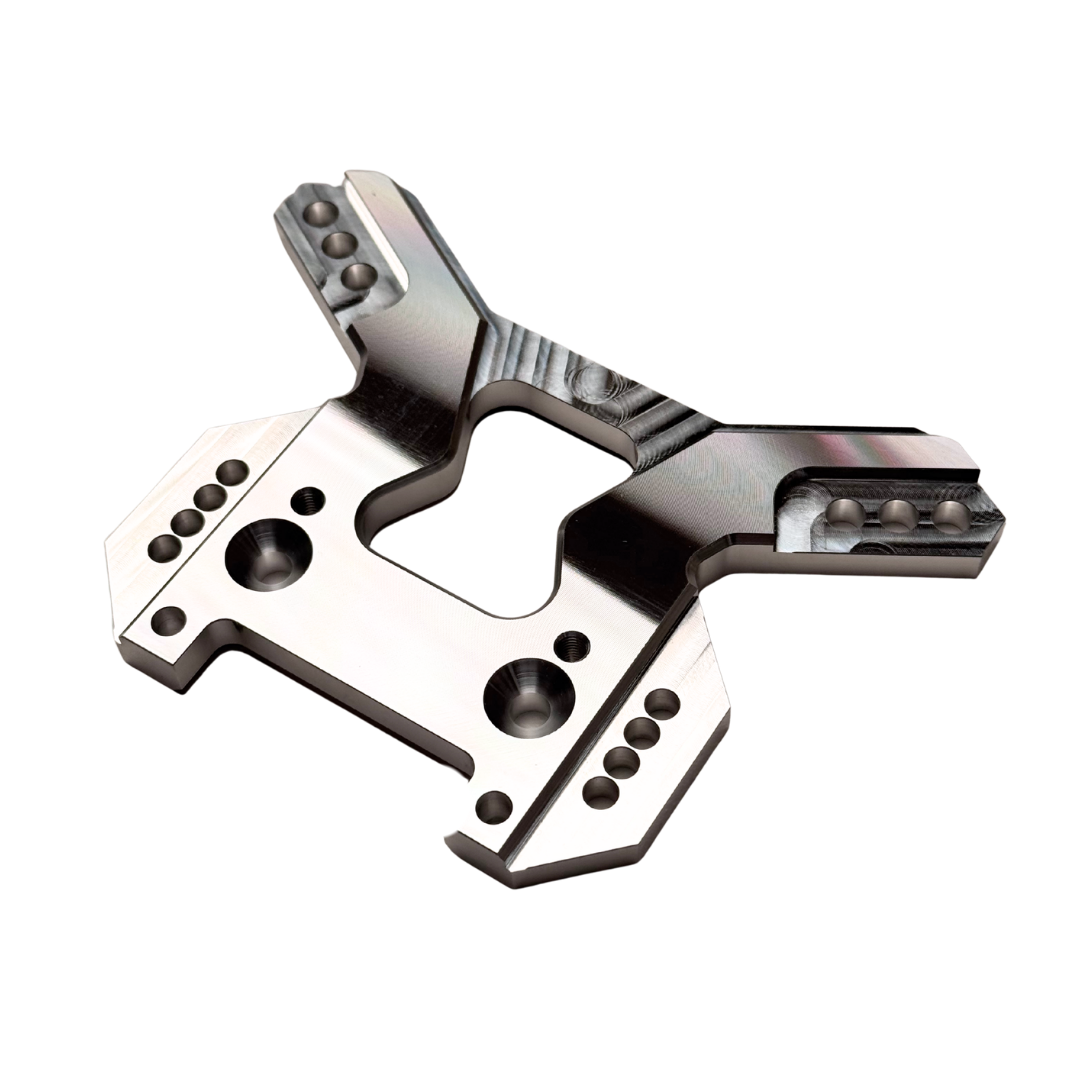 Taylor RC OUTLAW V4 front shock tower in raw silver, angled top-down view showing the full arm layout and central cutout