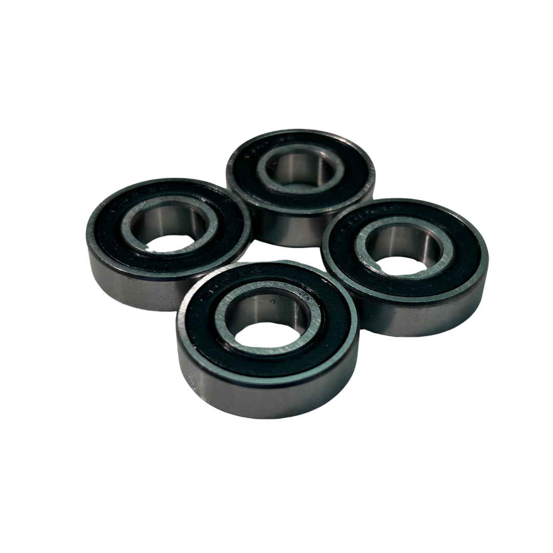 Four black cylindrical bearings on a white background