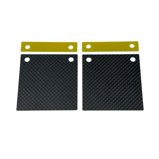 Two black carbon fiber plates with gold straps on a white background