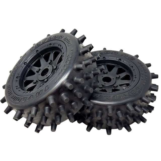Two black off-road wheels with spiky tread pattern on a white background