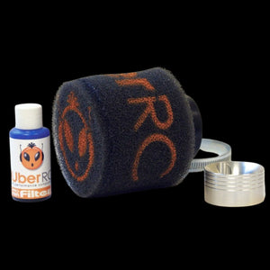 An air filter kit which includes a black filter with orange Uber RC branding, a bottle of Pro Air Filter Oil, and a velocity stack.